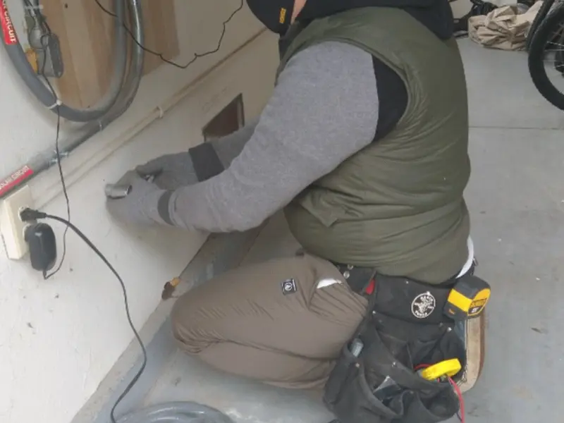 Electrician performing outlet wiring in a Jacksonville garage